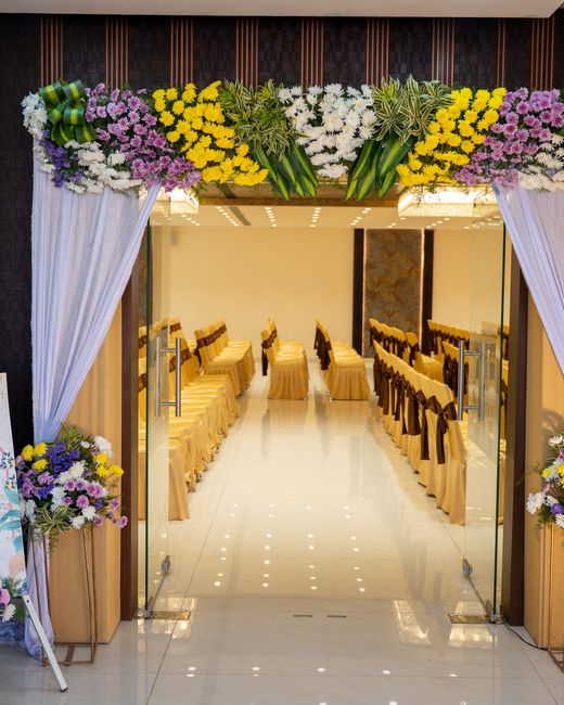 The floral entrance archway into a hall dressed for a ceremony