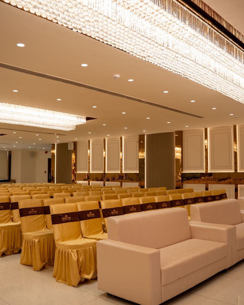 The main hall set with theatre seating under long crystal chandeliers