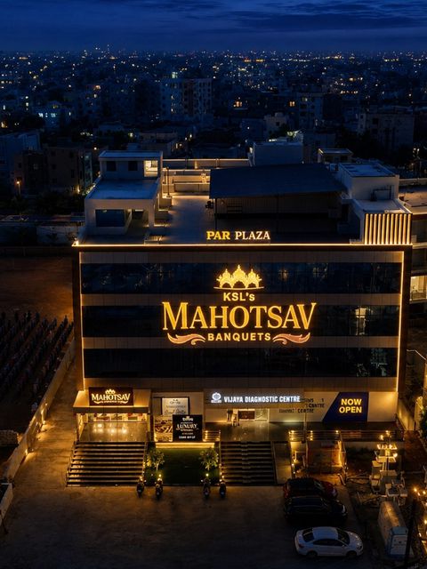 PAR Plaza lit in gold at dusk, with the Mahotsav Banquets sign on the facade